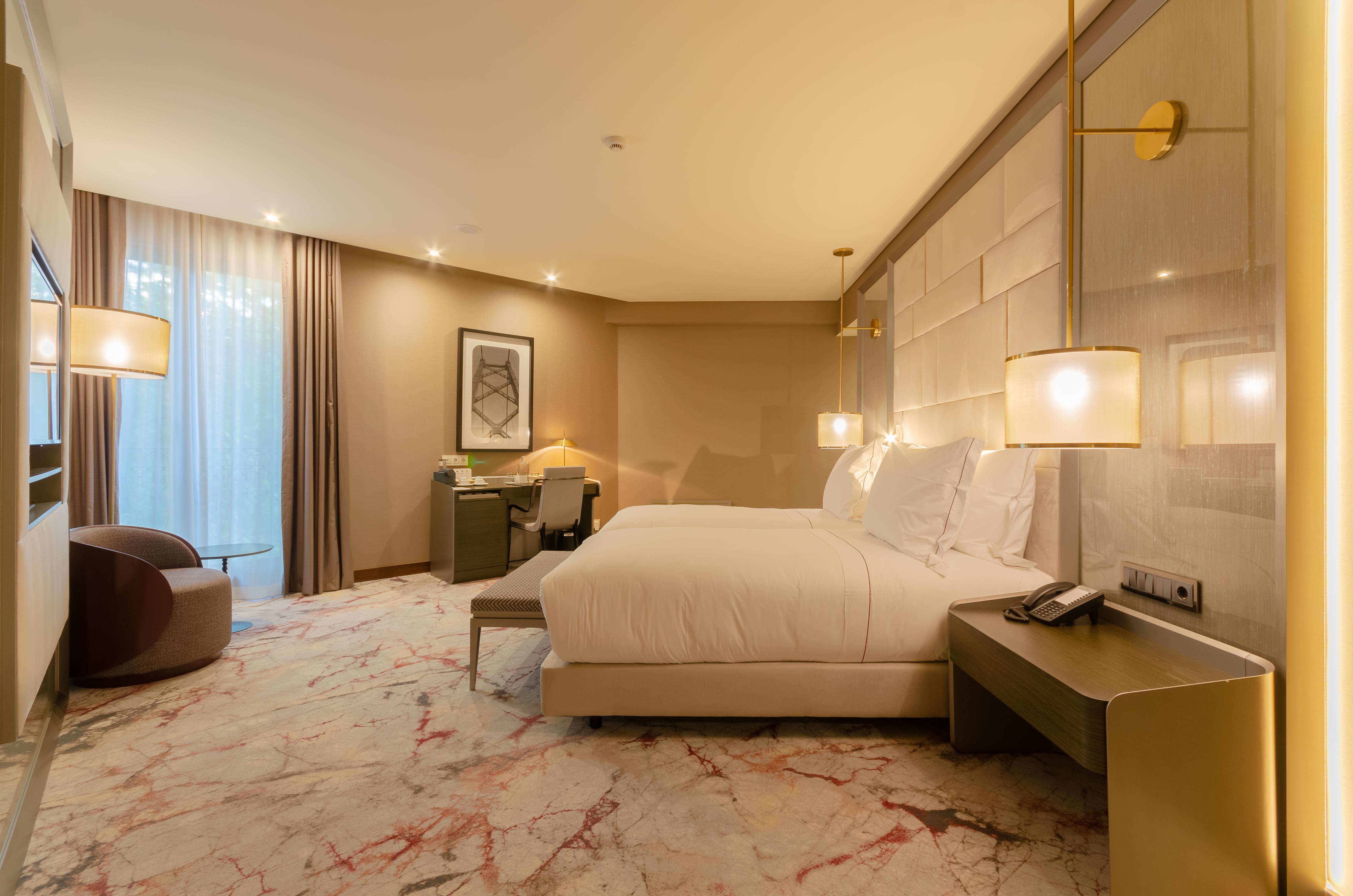 Turim Boulevard Hotel (Adults Only) Lisbona Esterno foto The photo showcases a well-designed hotel room that features modern and elegant decor. There are two large beds with white linens, placed against a soft-colored wall. The room is illuminated by stylish pendant lights, and there is a large window with