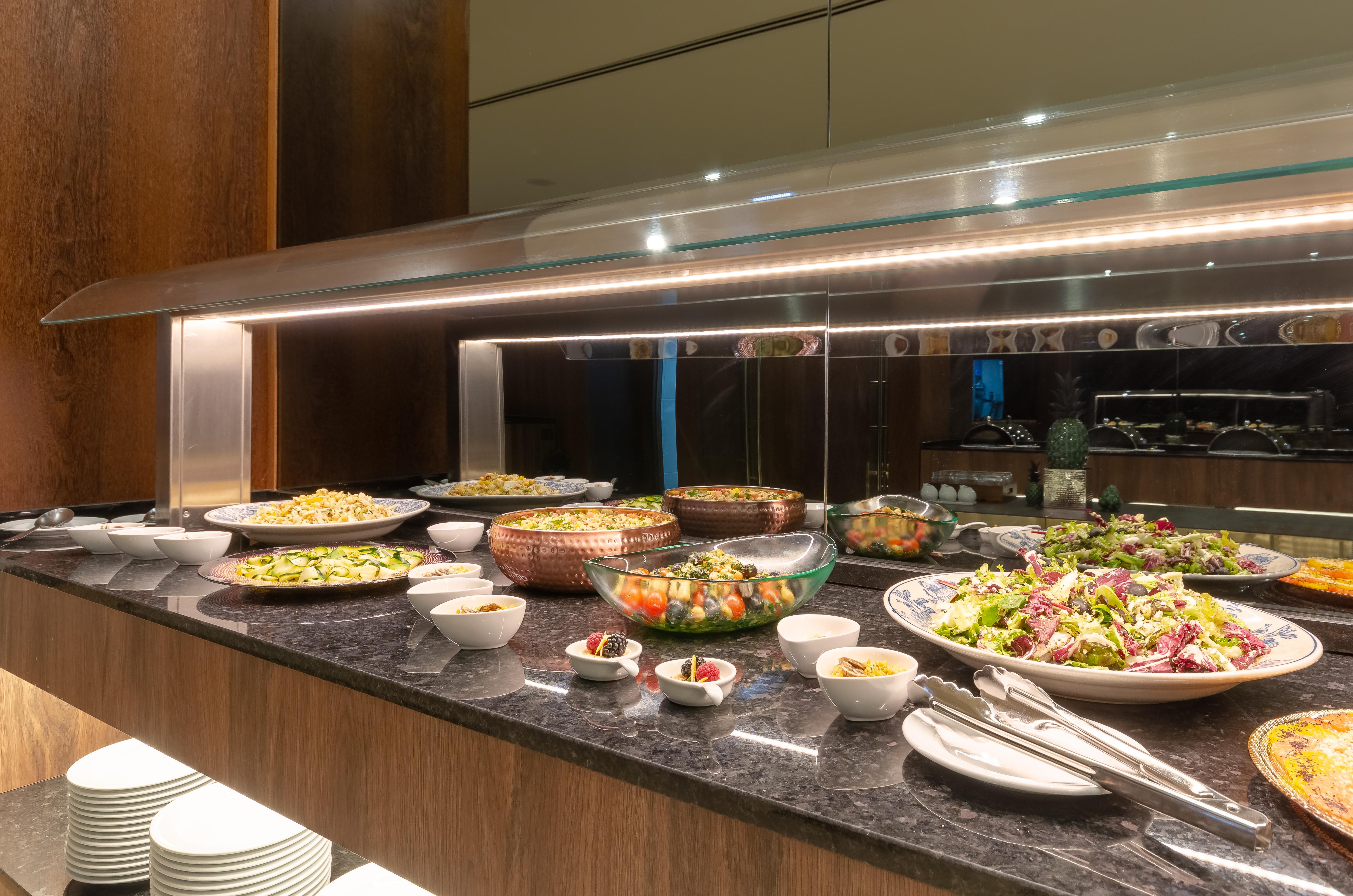 Turim Boulevard Hotel (Adults Only) Lisbona Esterno foto The photo features a buffet display with a variety of food items arranged on a counter. There are several bowls containing different types of salads, as well as dishes with grains and colorful vegetables. The setup includes serving utensils and small