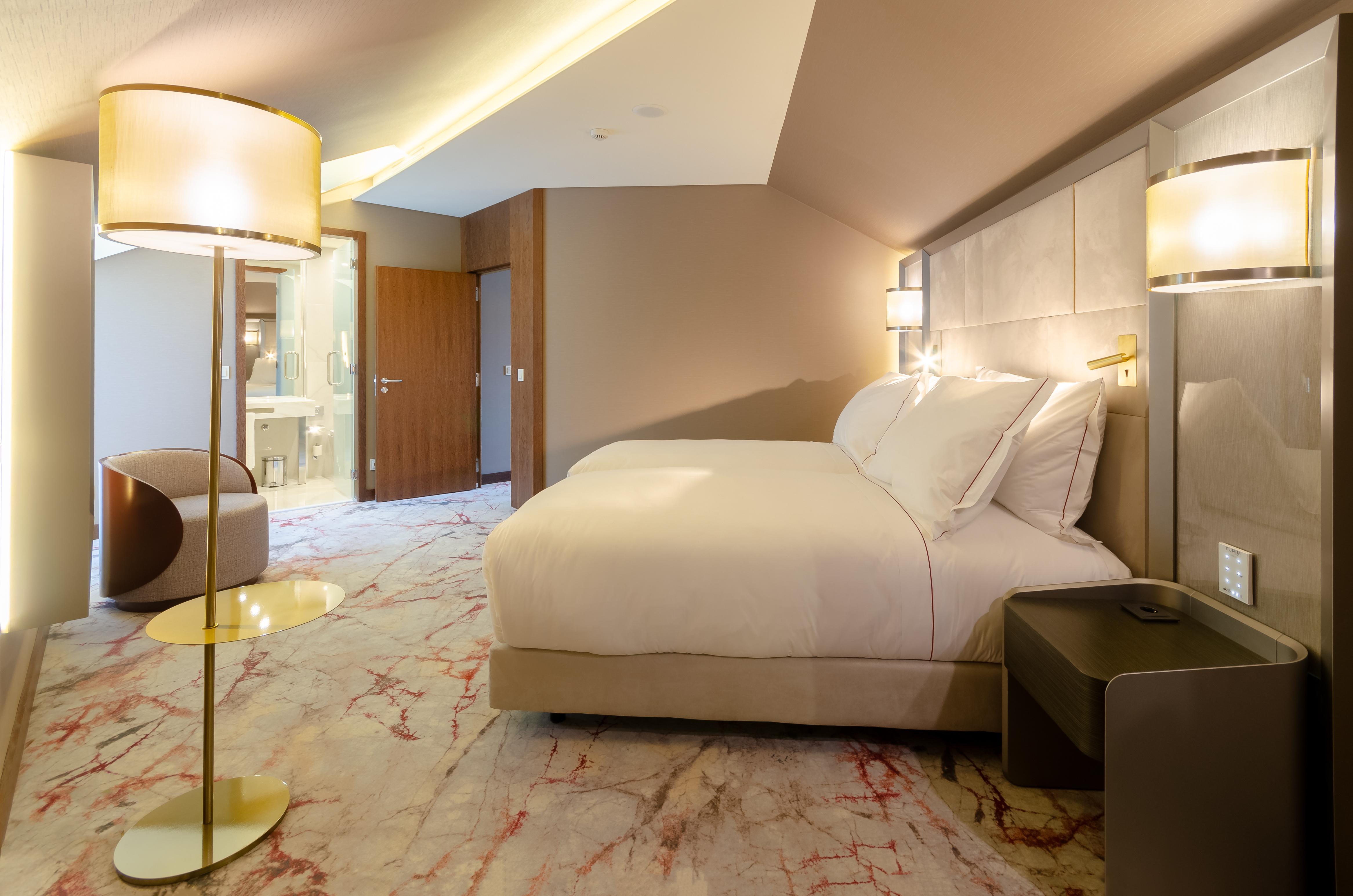 Turim Boulevard Hotel (Adults Only) Lisbona Esterno foto The photo shows a modern hotel room featuring a cozy double bed with white linens. The decor includes soft, neutral colors on the walls and a stylish carpet with marble-like patterns. A sleek nightstand is placed beside the bed, and there is a contem