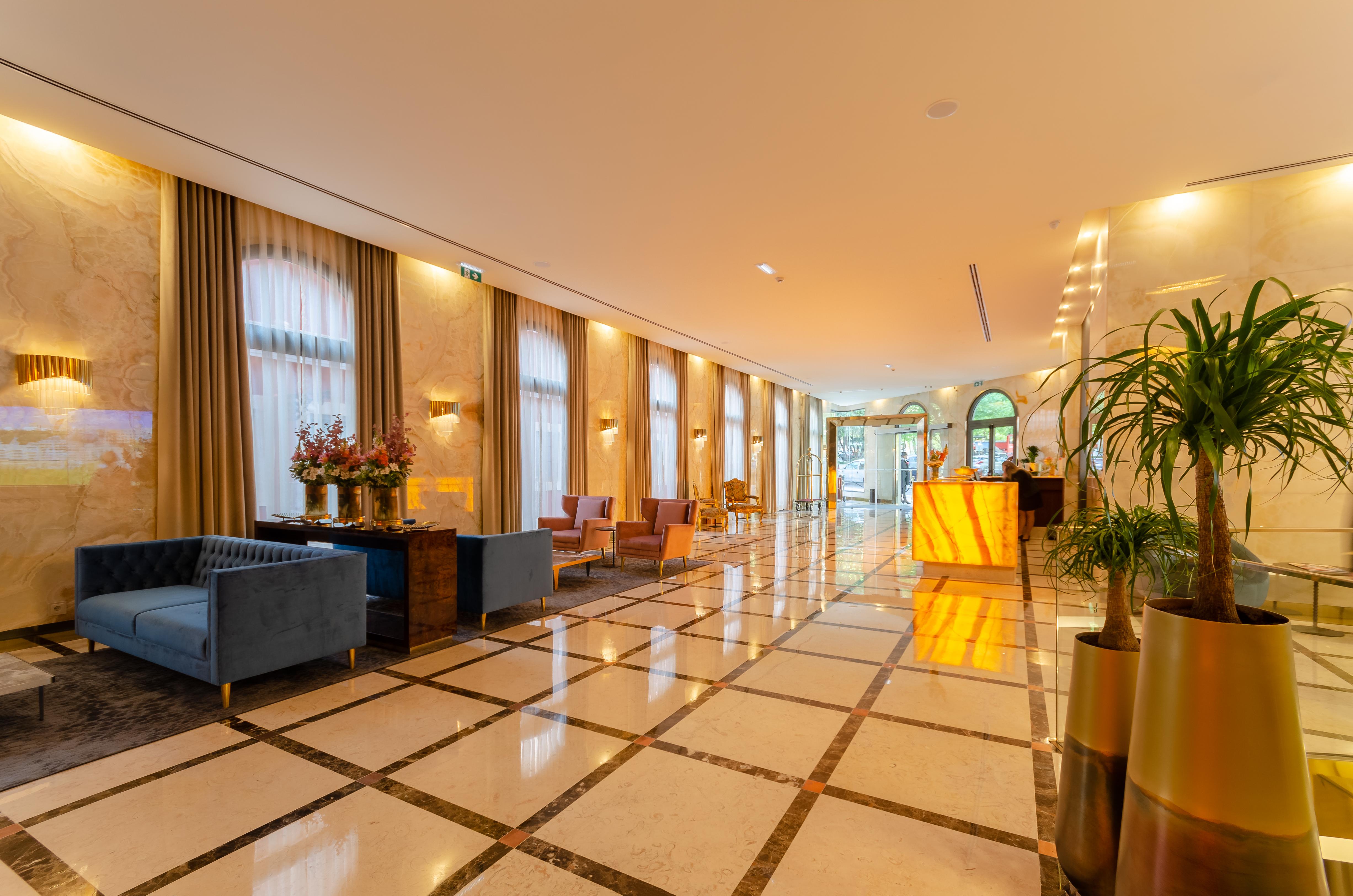 Turim Boulevard Hotel (Adults Only) Lisbona Esterno foto The photo shows a luxurious hotel lobby with a spacious and elegant design. It features polished marble flooring with a checkered pattern, complemented by large windows that illuminate the space with natural light. To the left, there are comfortable 