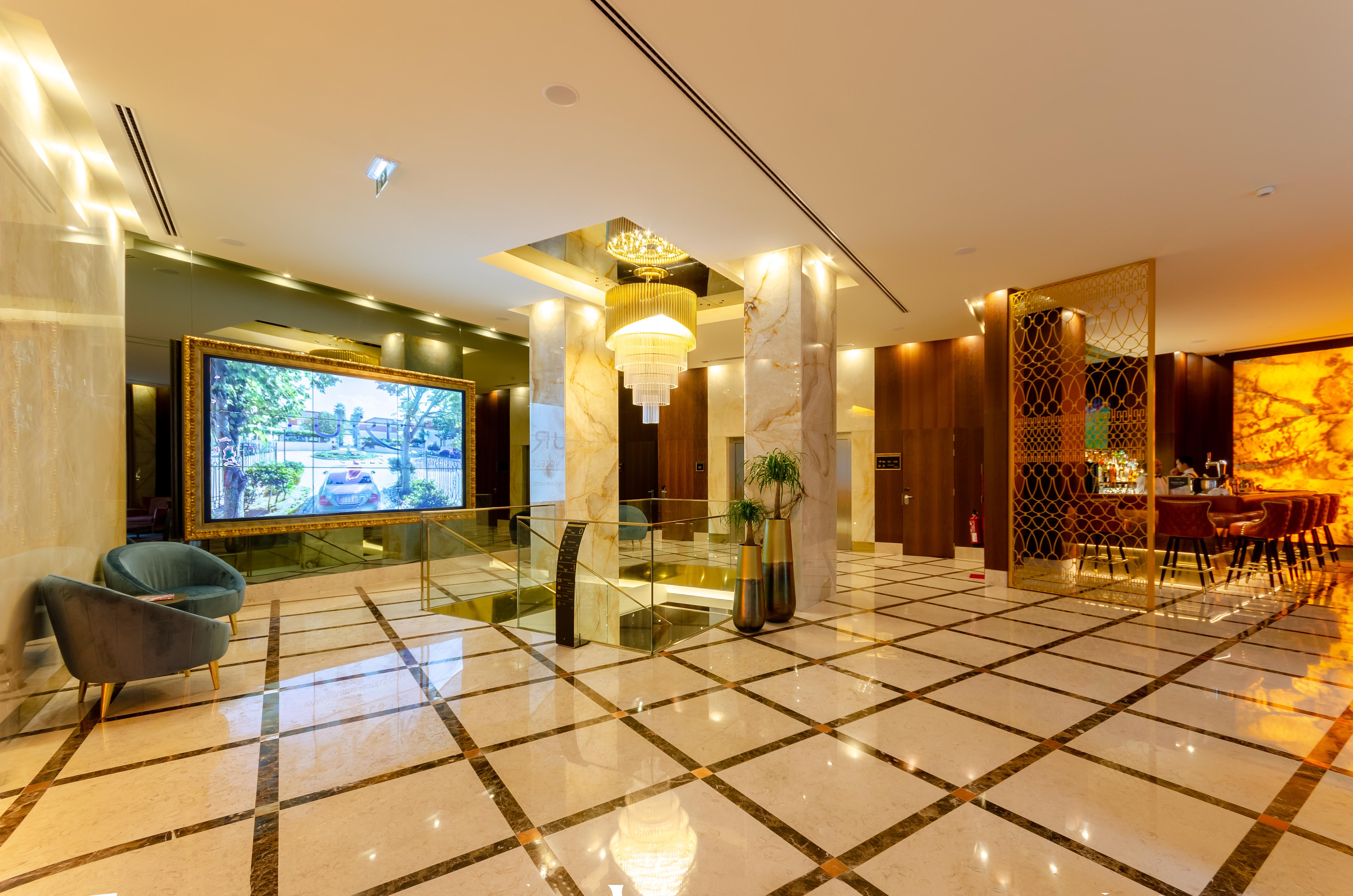 Turim Boulevard Hotel (Adults Only) Lisbona Esterno foto The photo shows a luxurious lobby area. The floor is adorned with large marble tiles arranged in a grid pattern, creating an elegant look. 

In the center, there is a decorative chandelier hanging from the ceiling, adding a touch of sophistication. 
